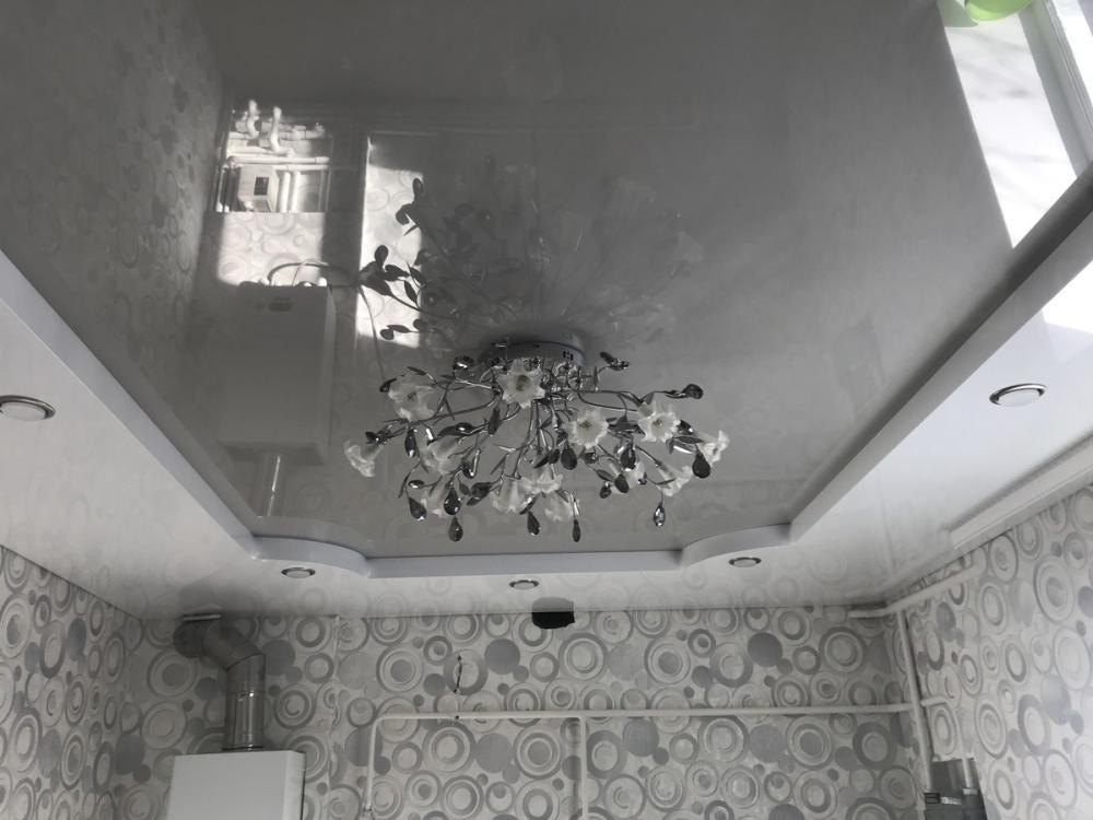 Двухуровневый глянцевый натяжной потолок с люстрой и светильниками по периметру фото 